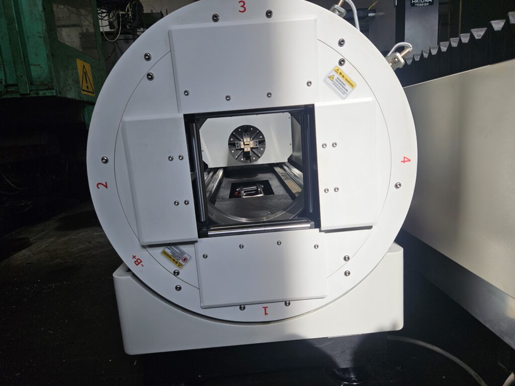 Laser fiber Aktona TR3015L-R 3kW. Ploter laserowy zamknięty do cięcia stali. Widoczny wysuwany stół.