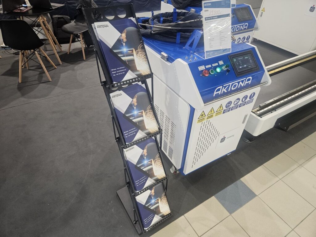Laser Aktona na stoisku Warsaw Industry Week 2025 obok stojaka z broszurami. Aktona TR-42000.